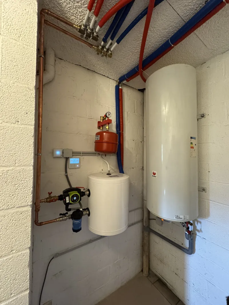 Ballon d'eau chaude sanitaire Bulex et vase d'expansion dans un local blanc