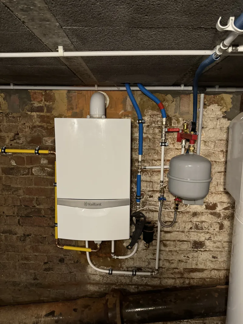 Chaudière gaz murale Vaillant ecoTEC avec vase d'expansion sur un mur en brique chaulée