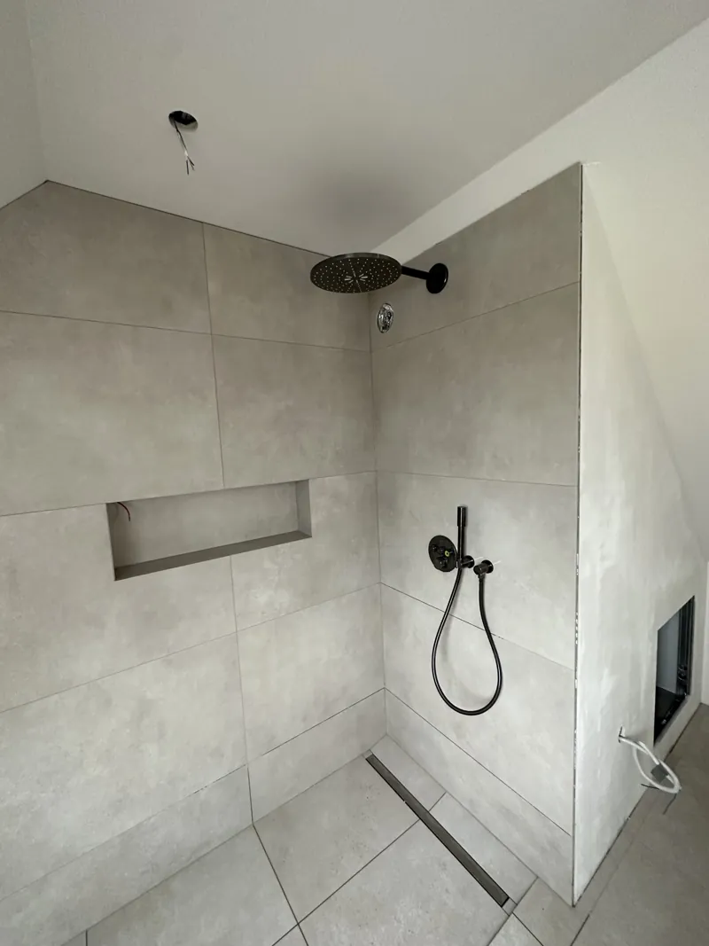 Douche à l'italienne carrelée en gris dans une salle de bain terminée