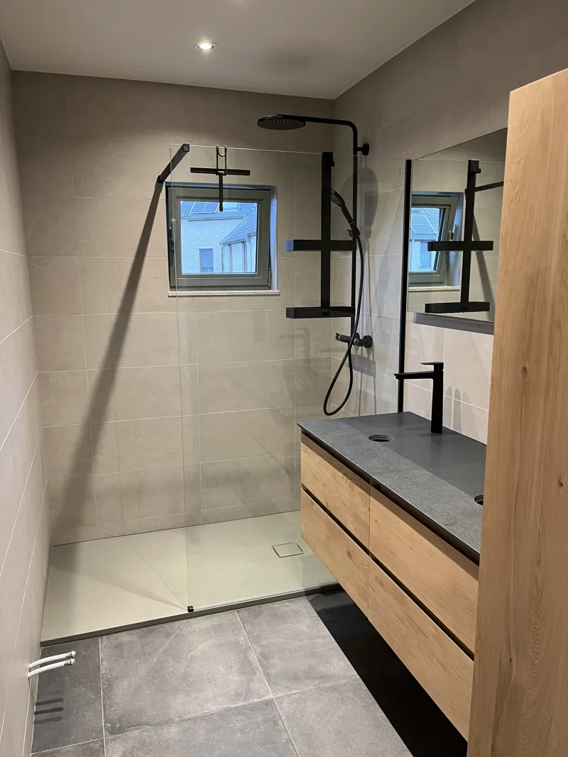 Douche et meuble vasque en bois dans une salle de bain terminée au carrelage gris